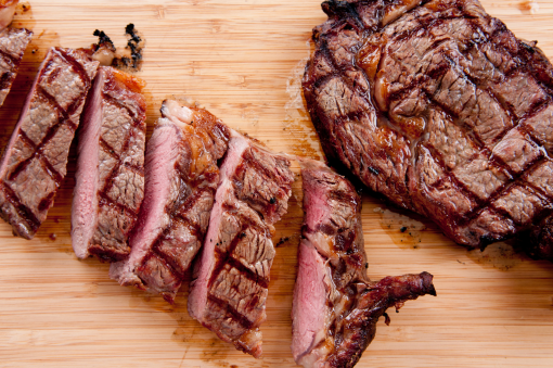 Dos trozos de carne sobre madera, una fileteada y la otra no